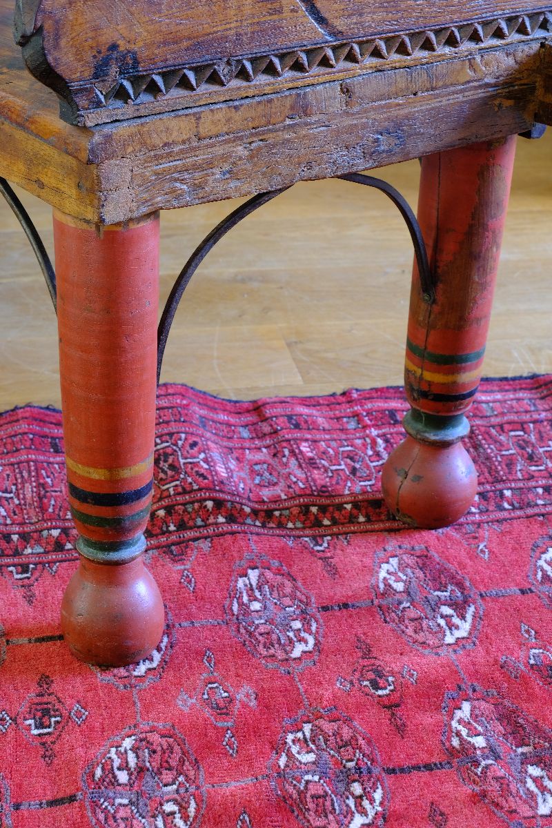 The surviving original terracotta polychrome legs and iron work on a Late 19th Century Gujarati Hardwood Hall Bench with Original Polychrome Finish, Turned Gallery Back and Brass Rosette Mounts

