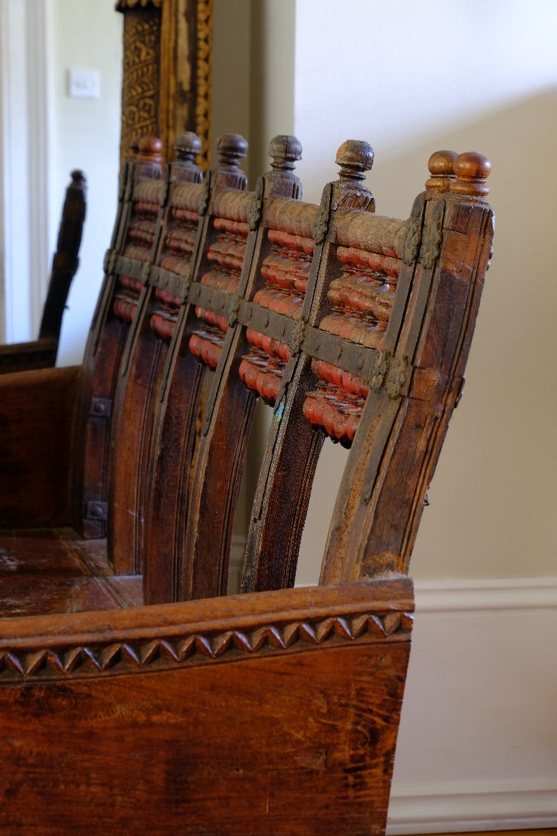 Side profile view showing the curved agronomical back on a on a Late 19th Century Gujarati Hardwood Hall Bench with Original Polychrome Finish, Turned Gallery Back and Brass Rosette Mounts