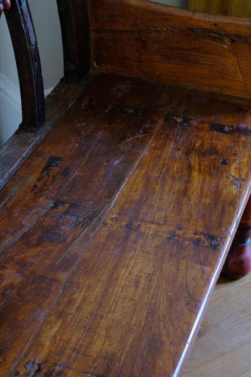 Close up of the bench seat on a Late 19th Century Gujarati Hardwood Hall Bench with Original Polychrome Finish, Turned Gallery Back and Brass Rosette Mounts