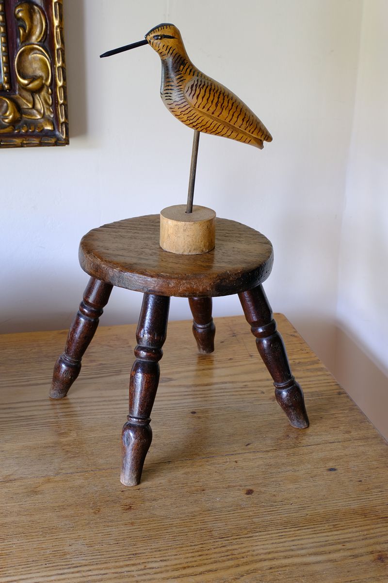 Antique English dairy milking stool with four turned legs and original dark painted finish