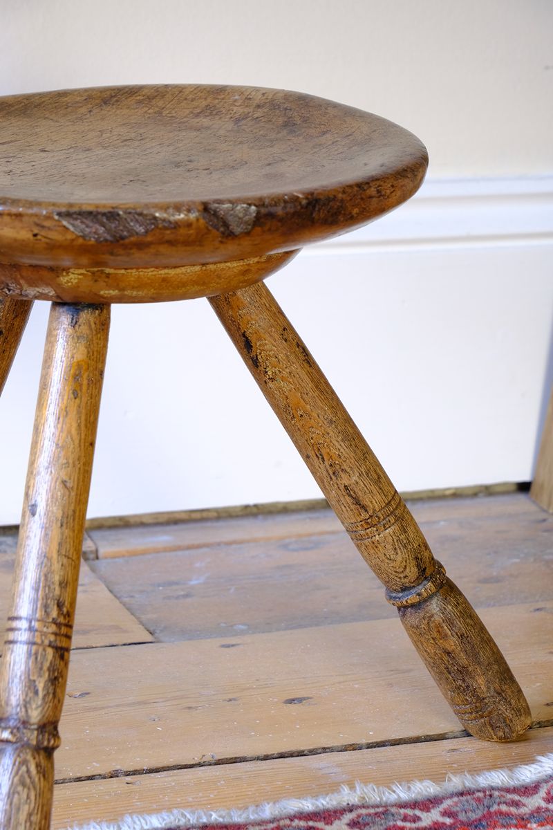 Old wear and detail on an 19th Century Vernacular Three Legged Sycamore Dairy Stool with Dished Seat