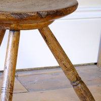Old wear and detail on an 19th Century Vernacular Three Legged Sycamore Dairy Stool with Dished Seat