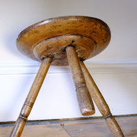 pronounced under-seat boss on this Early 19th Century Vernacular Three Legged Sycamore Dairy Stool with Dished Seat