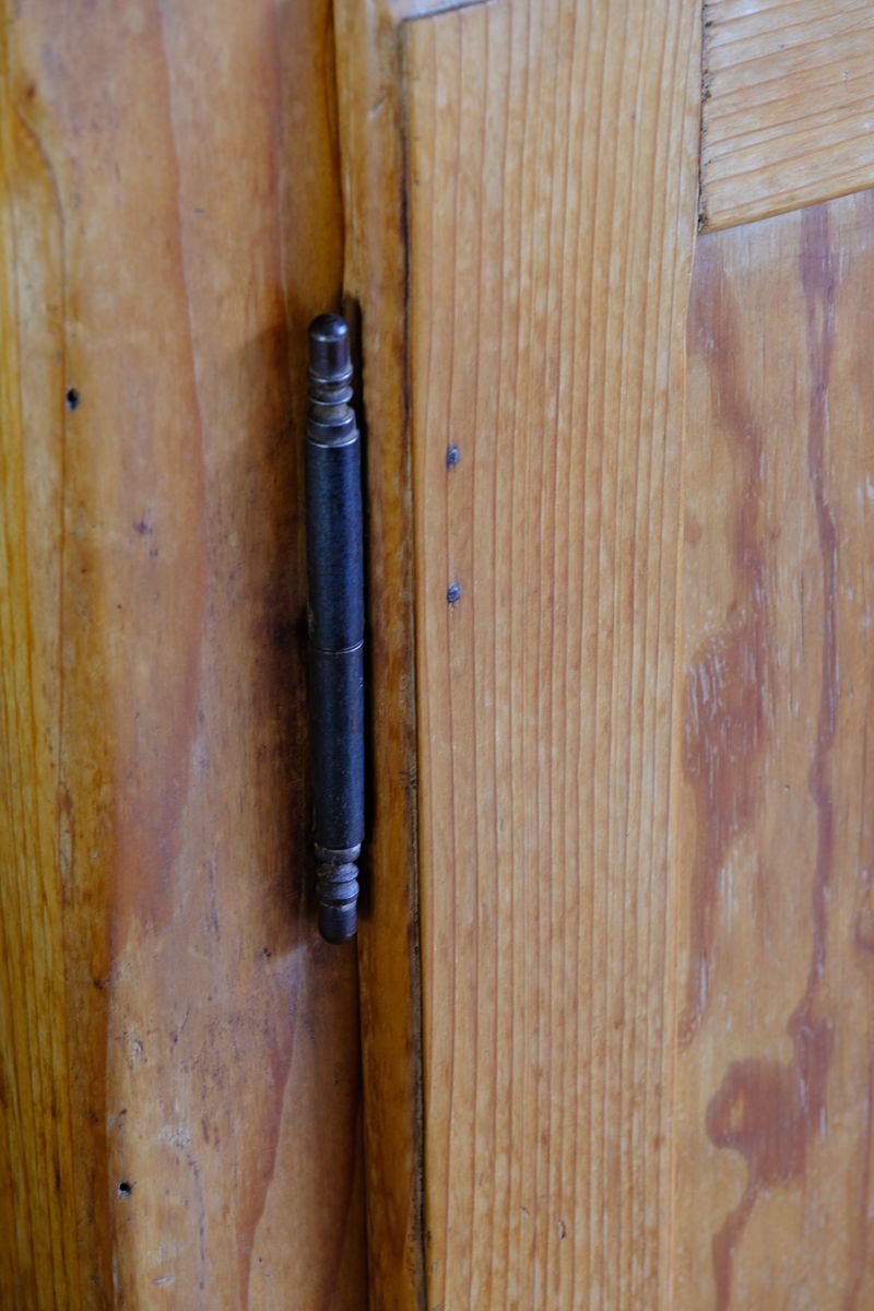 Close up of the brass and steel pin hinges on an Early 20th Century Pitch Pine Single Door Larder Cupboard with Lift-Off Hinges and Original Sprung Latch
