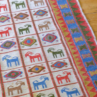 Traditional Persian Sumak wool flatweave rug with repeating goat motifs and geometric design