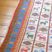 Vintage Persian Sumak flatweave rug with stylised goat and geometric motifs on an ivory ground
