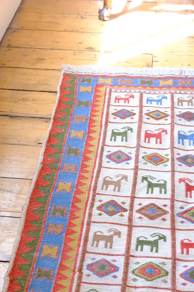Vintage Persian Sumak flatweave rug with stylised goat and geometric motifs on an ivory ground