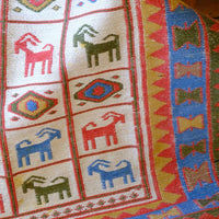 close up of a Traditional Persian Sumak wool flatweave rug with repeating goat motifs and geometric design