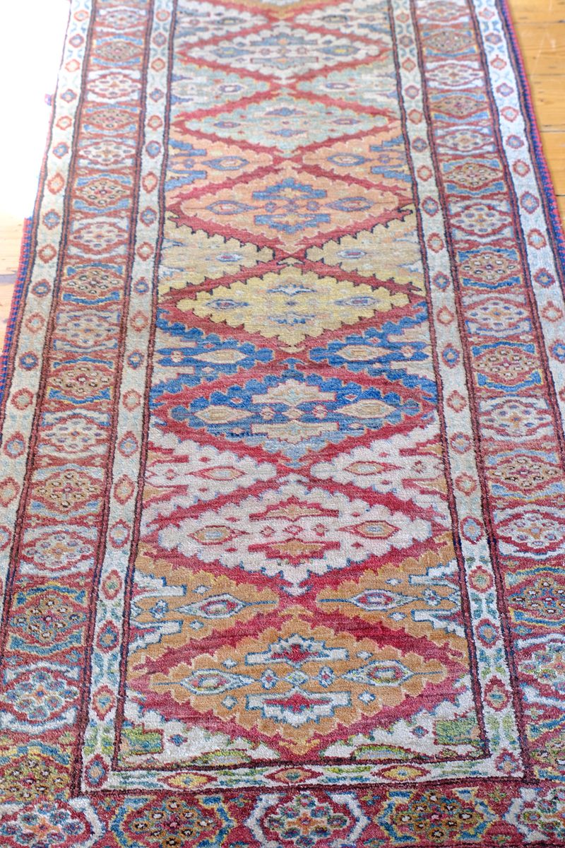 Mid section of the Mid-20th Century North-West Persian ivory ground hand-knotted wool runner with fourteen hooked lozenge medallions
