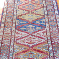 Mid section of the Mid-20th Century North-West Persian ivory ground hand-knotted wool runner with fourteen hooked lozenge medallions