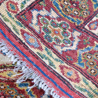 close up of the back of the Mid-20th Century North-West Persian ivory ground hand-knotted wool runner with fourteen hooked lozenge medallions