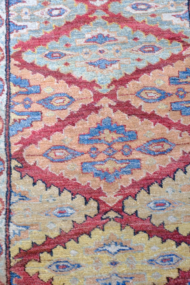 Hooked lozenge medallions on the Mid-20th Century North-West Persian ivory ground hand-knotted wool runner with fourteen hooked lozenge medallions