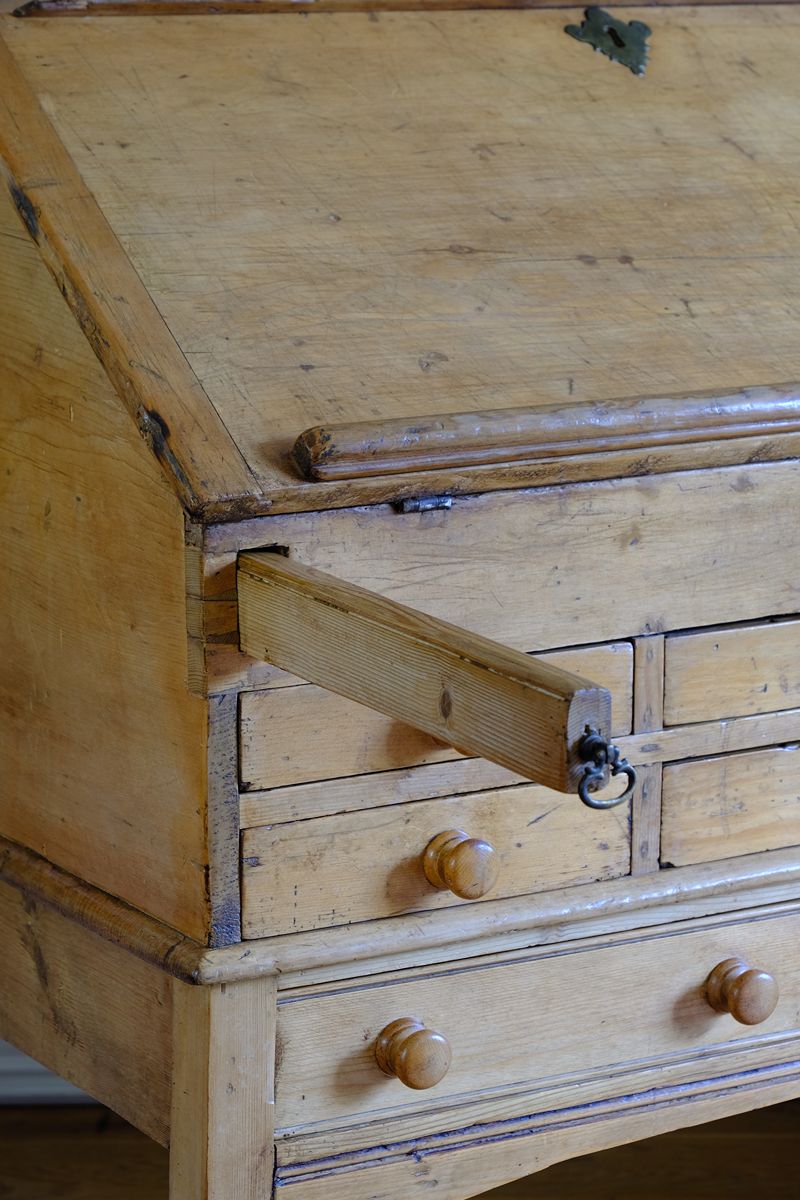 Two retractable wooden lopers pull forward to support the fall horizontally, creating a substantial writing surface.. Early 19th Century Georgian Pine Fall-Front Writing Bureau Desk c.1820–1840