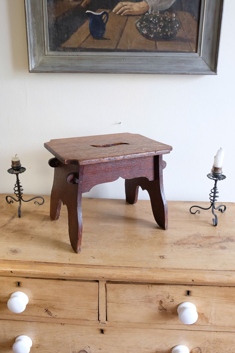 Antique Arts and Crafts oak low stool with S-shaped carrying handle, fret-cut arches and exposed keyed through-tenons, circa 1900.