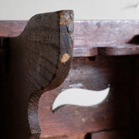 Wear on the underside of the leg of the Antique Arts and Crafts oak low stool with S-shaped carrying handle, fret-cut arches and exposed keyed through-tenons, circa 1900.