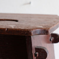 Projecting through-tenons secured by shaped wooden keys on this Antique Arts and Crafts oak low stool with S-shaped carrying handle, fret-cut arches and exposed keyed through-tenons, circa 1900.