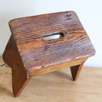 Rigid grain on a 19th Century Vernacular Pine Stool with V-Cut Sides and Worn Grab Handle Seat