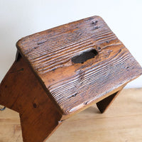 Seat grain on a 19th Century Vernacular Pine Stool with V-Cut Sides and Worn Grab Handle Seat
