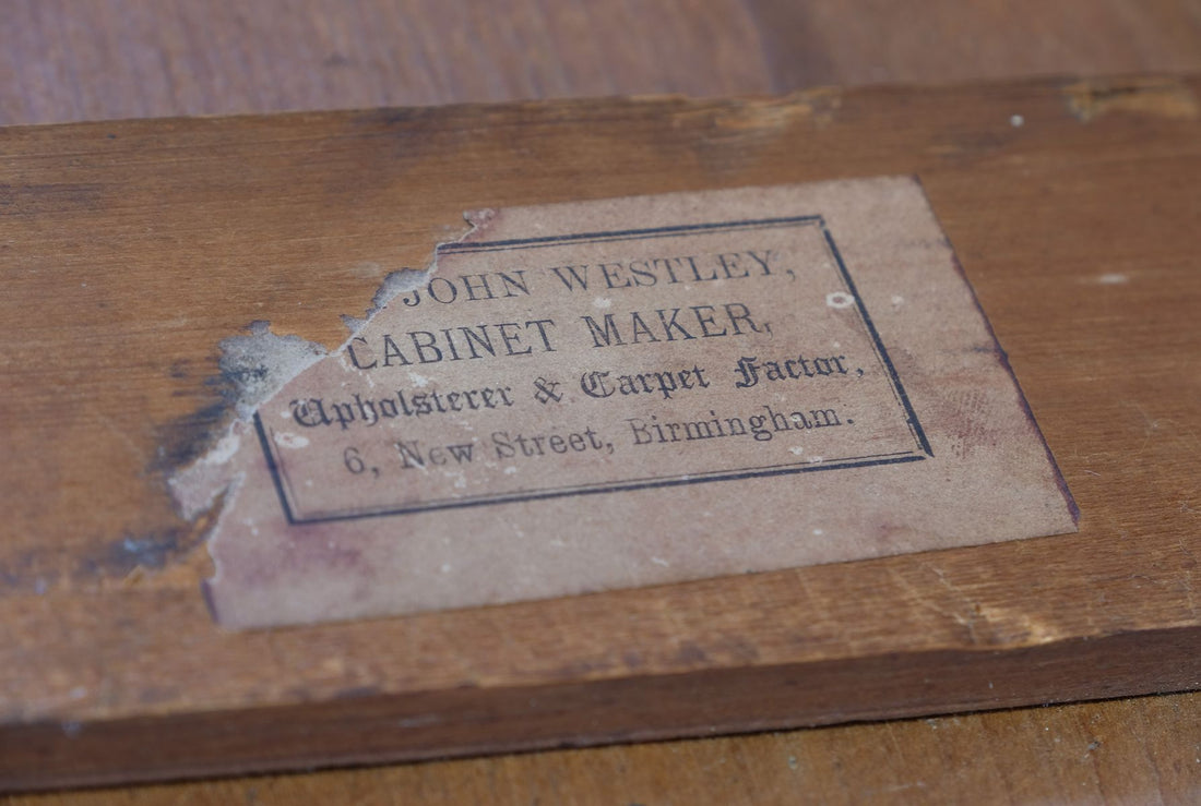 Comparison with another surviving labelled Westley object allows the missing portion of the label to be understood with considerable confidence. A complete example reads “FROM JOHN WESTLEY, CABINET MAKER, Upholsterer & Carpet Factor, 6, New Street, Birmingham.” The surviving wording, typography, layout and distinctive border correspond closely with the label on this mirror.
