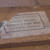 Comparison with another surviving labelled Westley object allows the missing portion of the label to be understood with considerable confidence. A complete example reads “FROM JOHN WESTLEY, CABINET MAKER, Upholsterer & Carpet Factor, 6, New Street, Birmingham.” The surviving wording, typography, layout and distinctive border correspond closely with the label on this mirror.