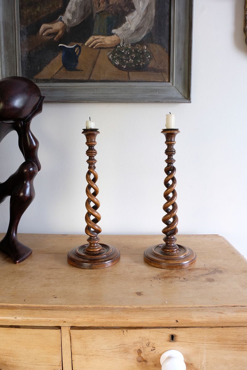 Pair of tall antique oak open barley twist candlesticks with original brass sconces and weighted circular bases