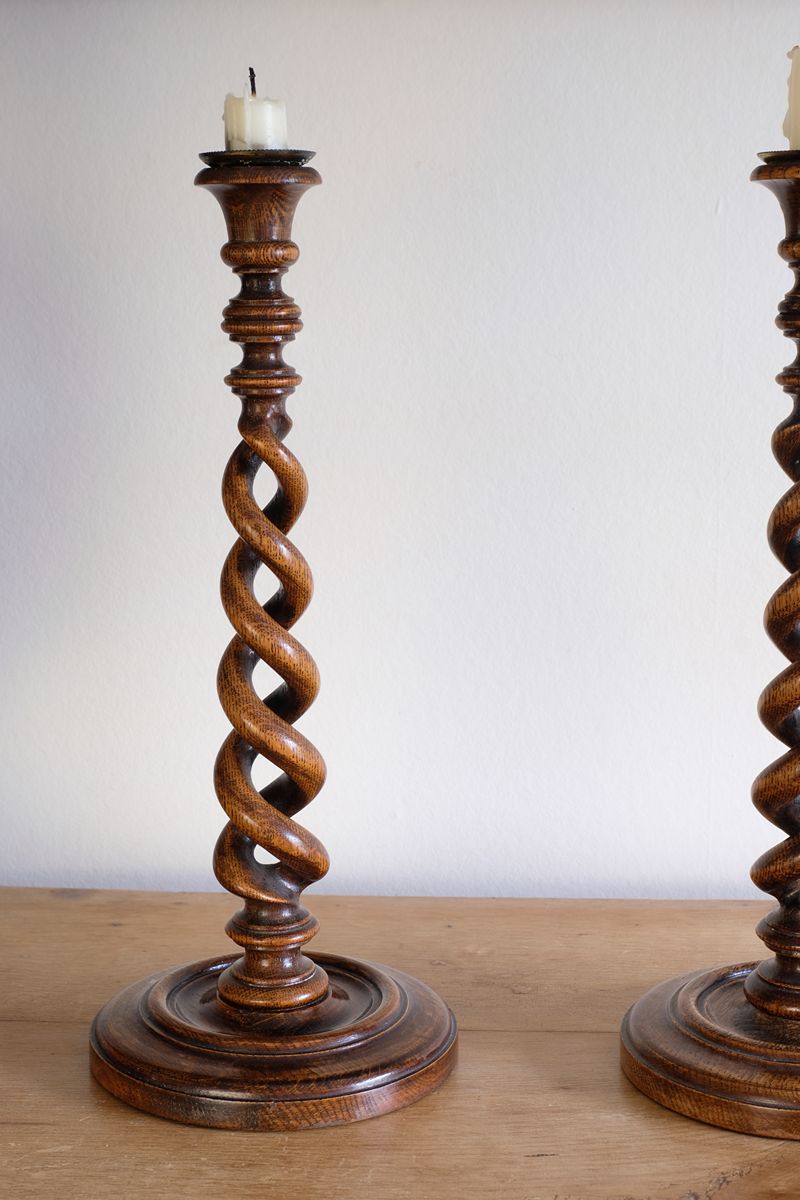 Pair of tall antique oak open barley twist candlesticks with original brass sconces and weighted circular bases