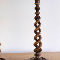 Pair of tall antique oak open barley twist candlesticks with original brass sconces and weighted circular bases