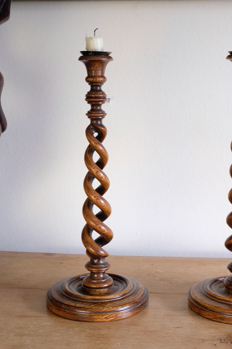 Pair of tall antique oak open barley twist candlesticks with original brass sconces and weighted circular bases