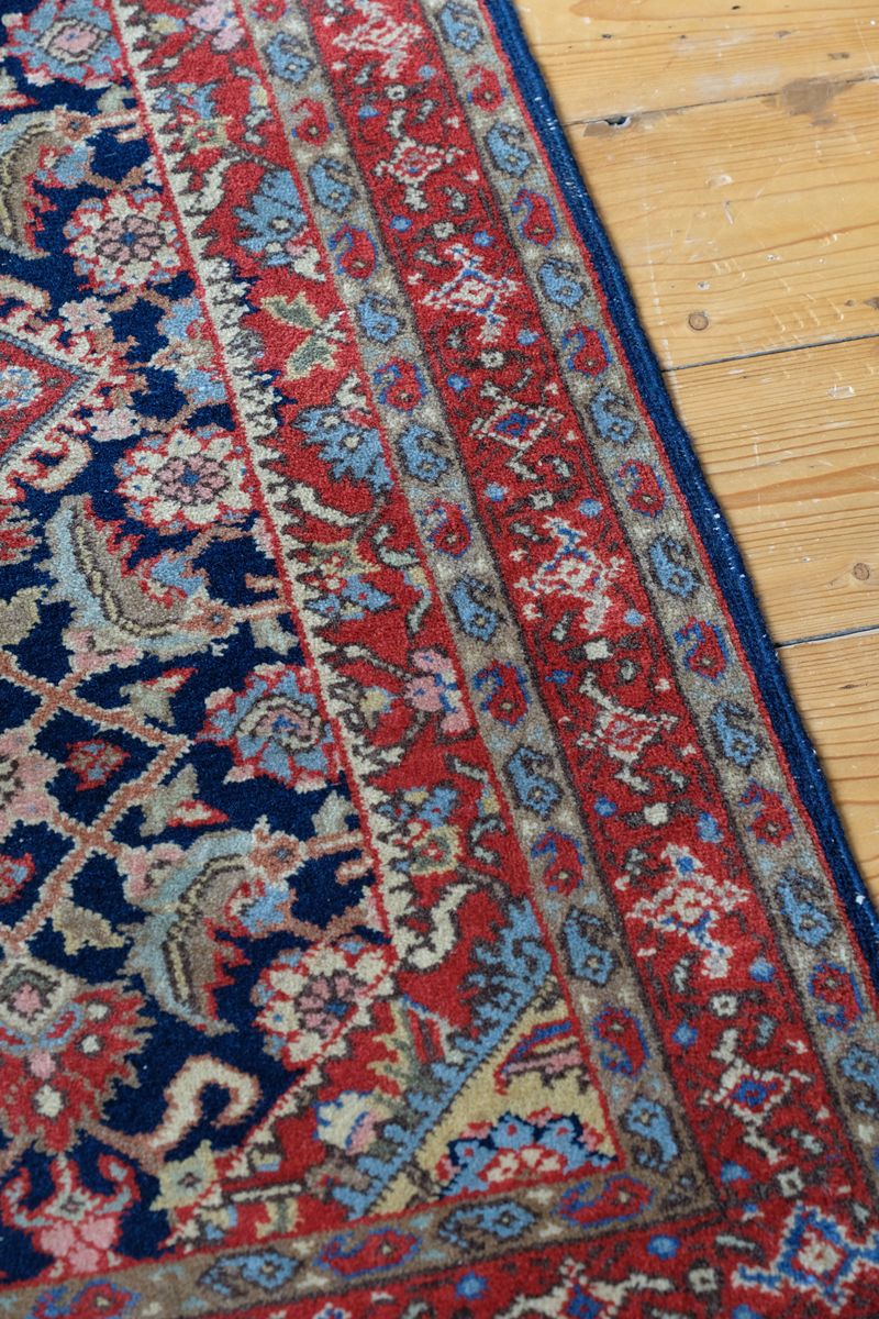 Hand-knotted floral lattice surrounding the geometric field medallions