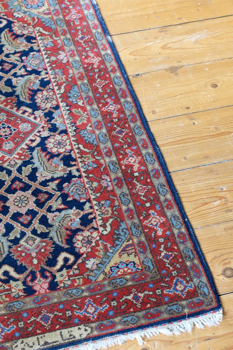 Antique North-West Persian runner displayed upright in natural light