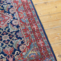 Antique North-West Persian runner displayed upright in natural light