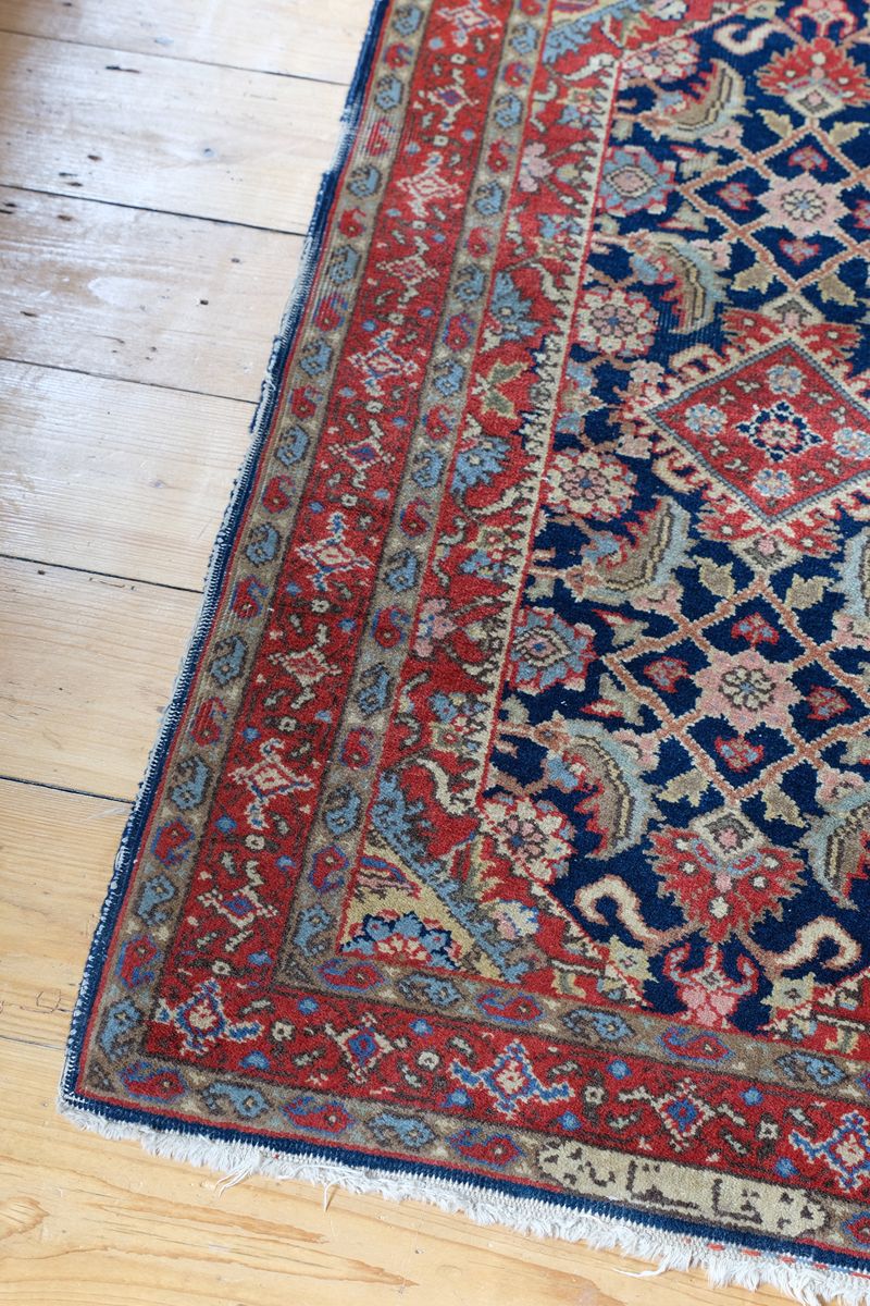 corner fringe detail on an Antique North-West Persian runner displayed upright in natural light