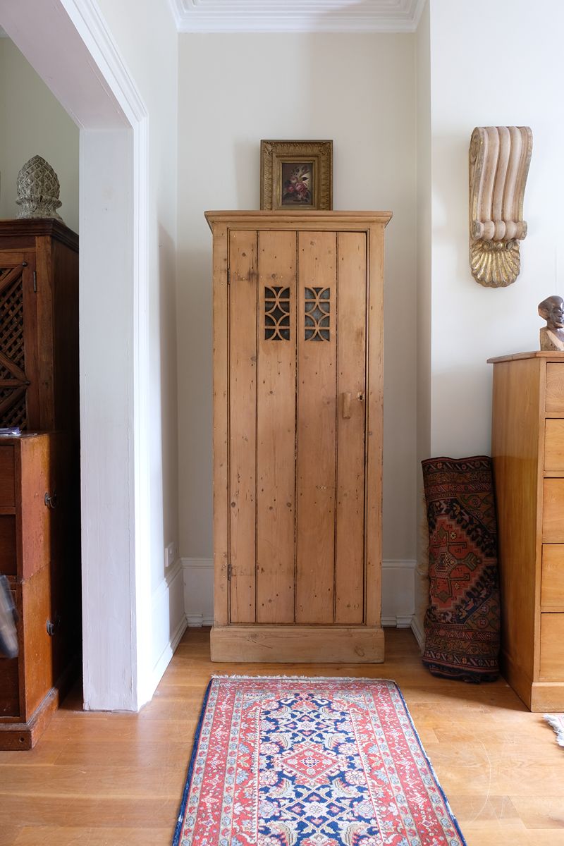 Antique pine cupboard, circa 1890–1910, with a boarded door, two pierced ventilation panels and a plinth base