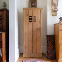 Antique pine cupboard, circa 1890–1910, with a boarded door, two pierced ventilation panels and a plinth base