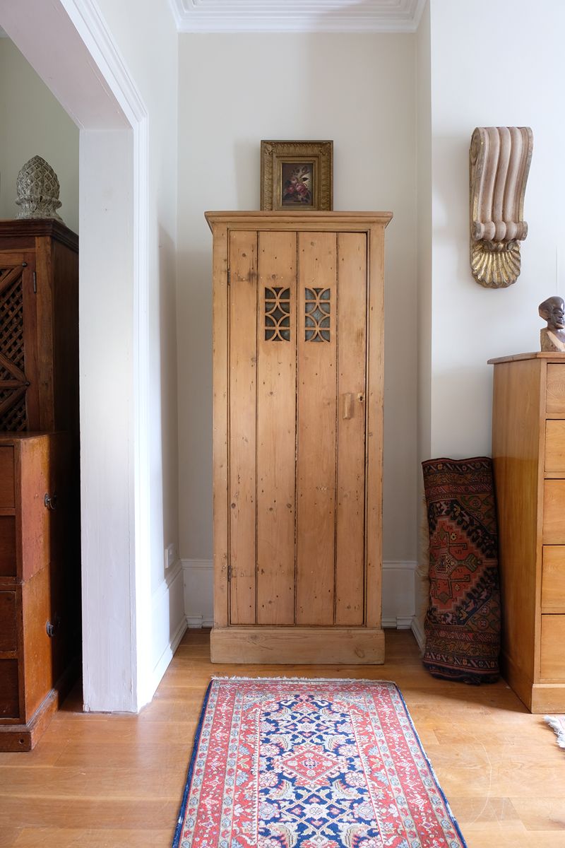 Antique pine cupboard, circa 1890–1910, with a boarded door, two pierced ventilation panels and a plinth base