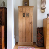 Antique pine cupboard, circa 1890–1910, with a boarded door, two pierced ventilation panels and a plinth base