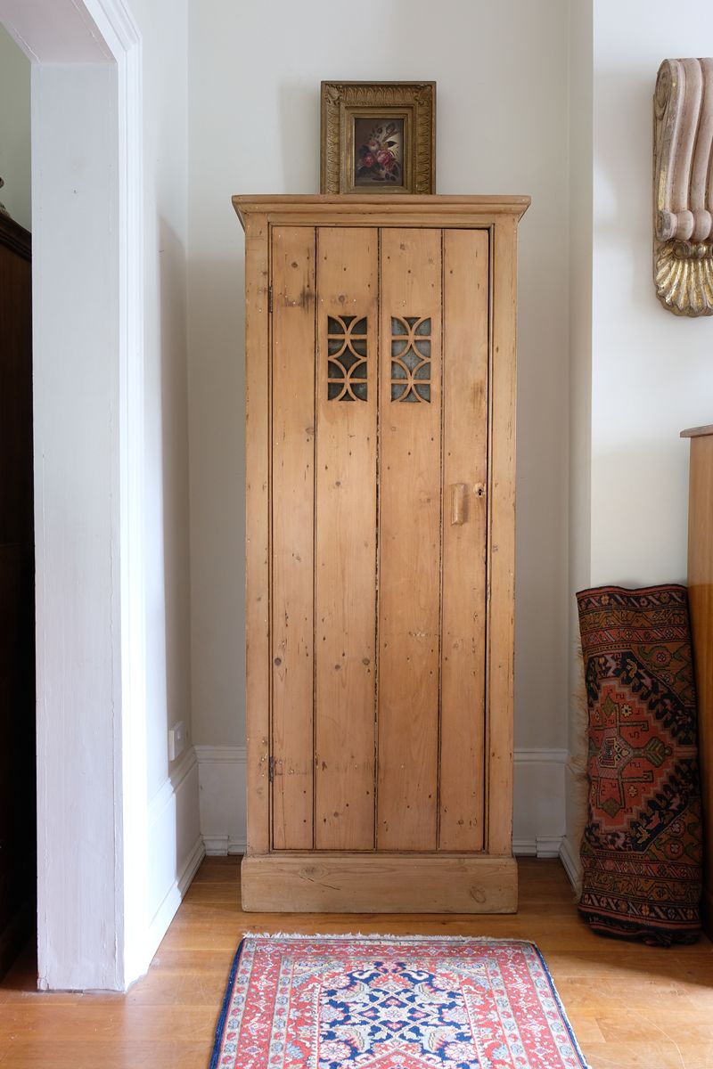 Antique pine cupboard, circa 1890–1910, with a boarded door, two pierced ventilation panels and a plinth base
