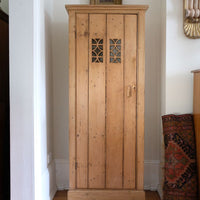 Antique pine cupboard, circa 1890–1910, with a boarded door, two pierced ventilation panels and a plinth base