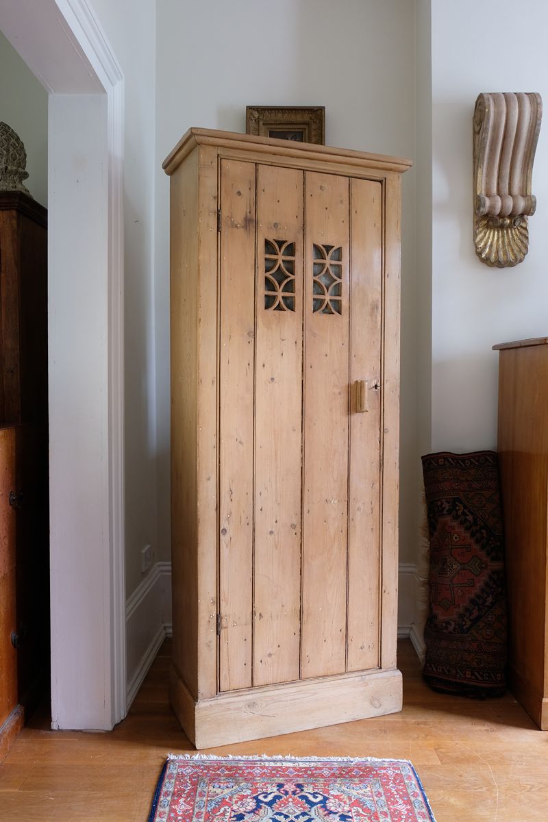 Antique pine cupboard, circa 1890–1910, with a boarded door, two pierced ventilation panels and a plinth base