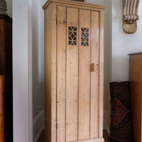 Antique pine cupboard, circa 1890–1910, with a boarded door, two pierced ventilation panels and a plinth base