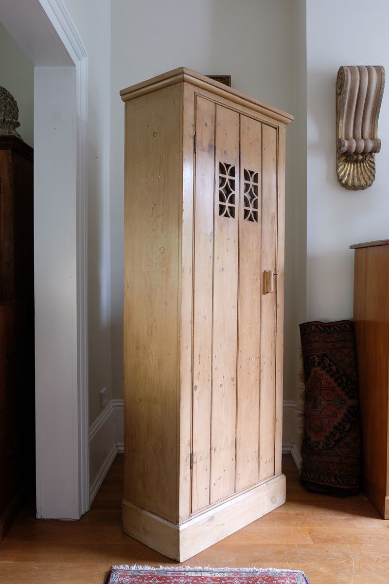 Antique pine cupboard, circa 1890–1910, with a boarded door, two pierced ventilation panels and a plinth base
