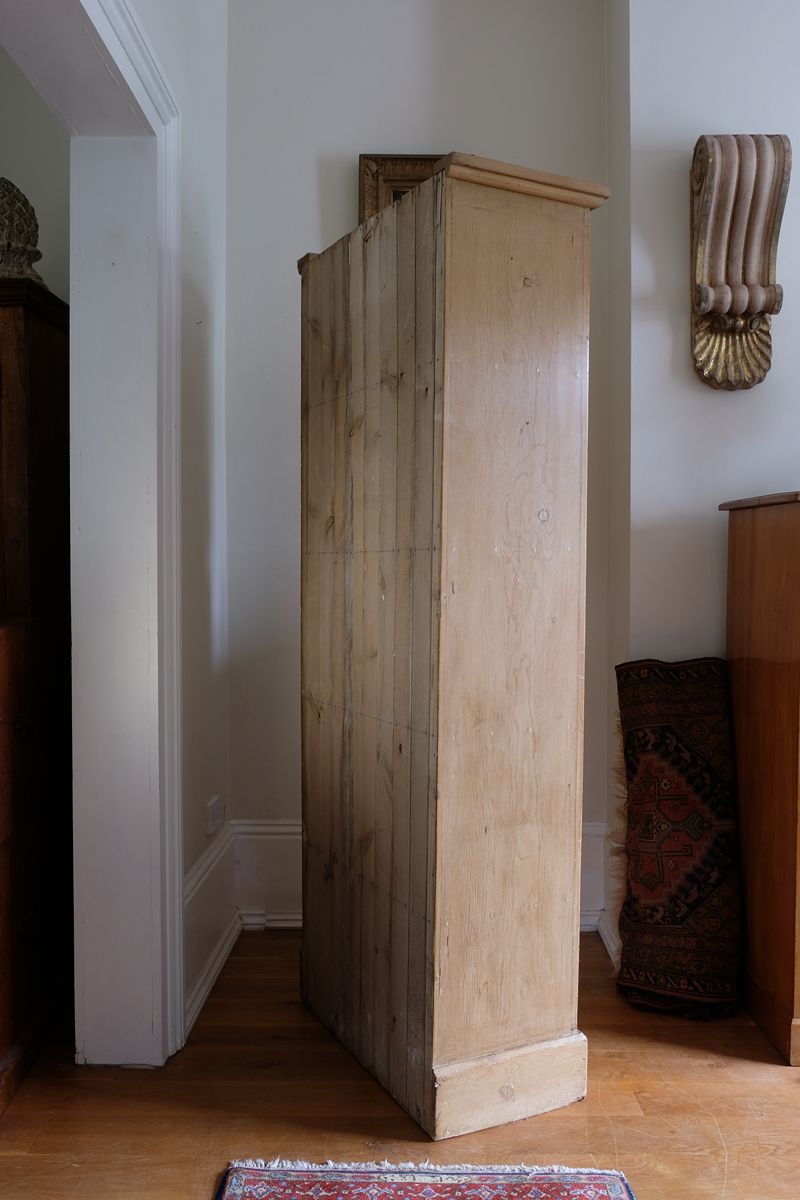 side panel on the Antique pine cupboard, circa 1890–1910, with a boarded door, two pierced ventilation panels and a plinth base