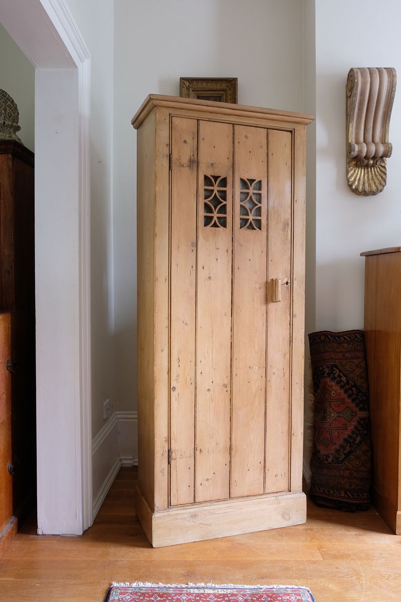 Antique pine cupboard, circa 1890–1910, with a boarded door, two pierced ventilation panels and a plinth base