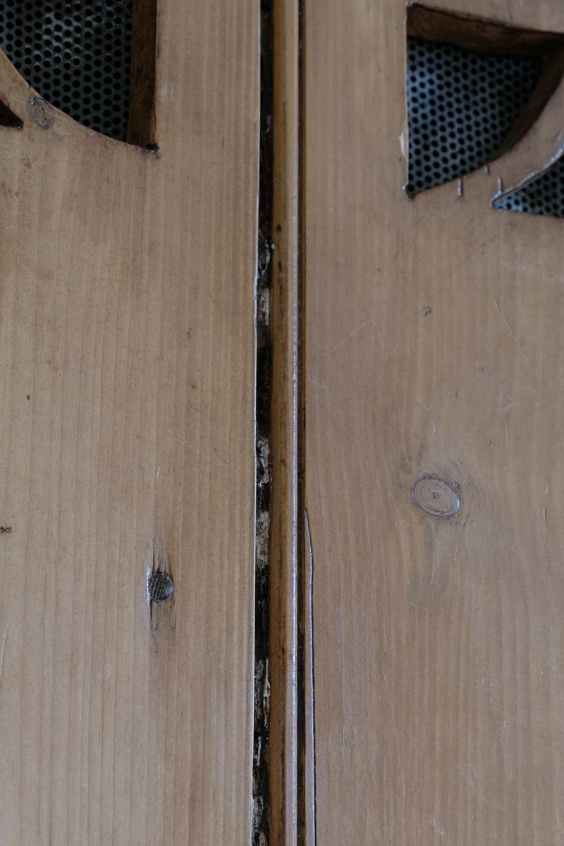 Antique pine cupboard, circa 1890–1910, with a boarded door, two pierced ventilation panels and a plinth base