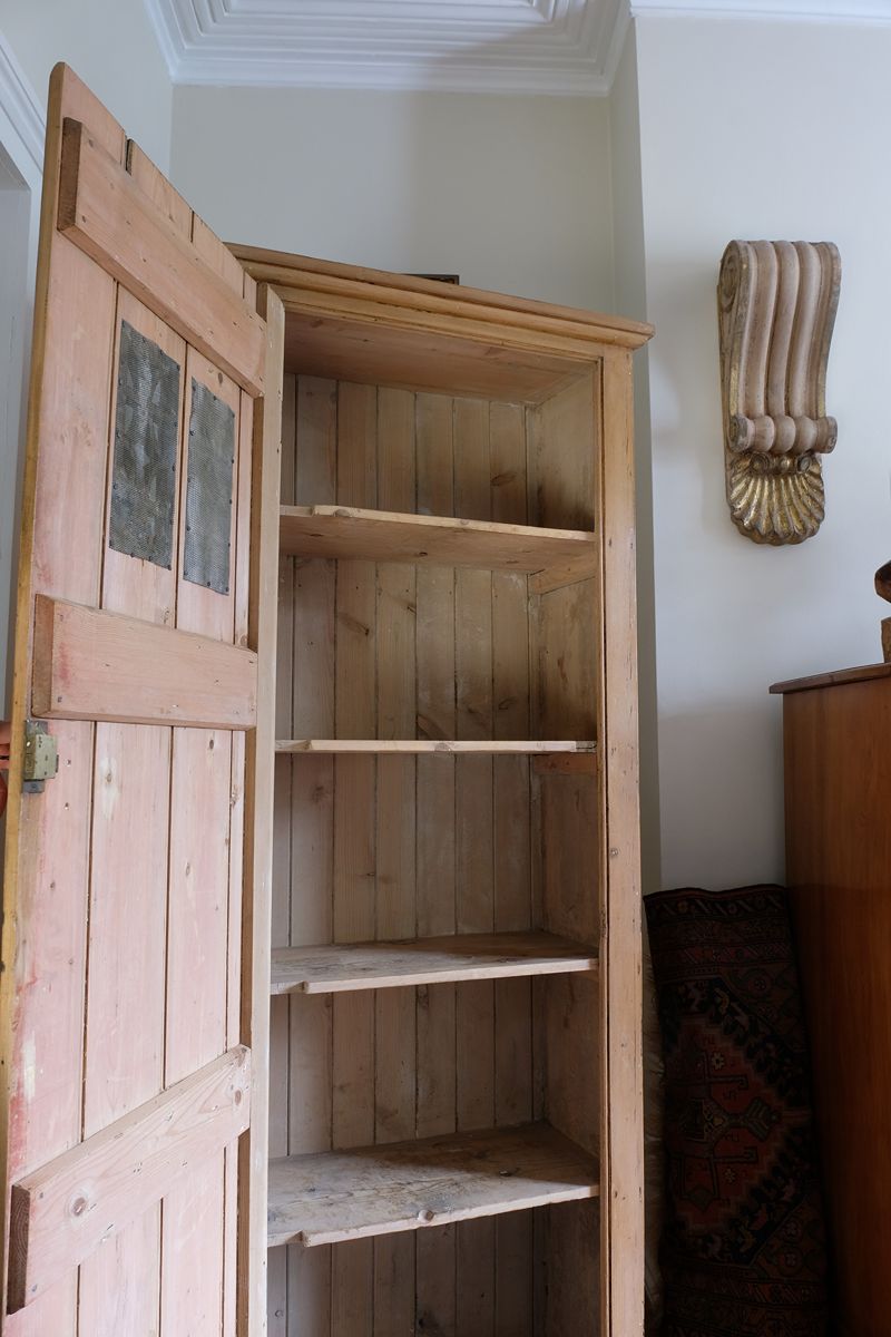 inside the Antique pine cupboard, circa 1890–1910, with a boarded door, two pierced ventilation panels and a plinth base
