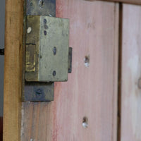 close up of the working lock on the Antique pine cupboard, circa 1890–1910, with a boarded door, two pierced ventilation panels and a plinth base