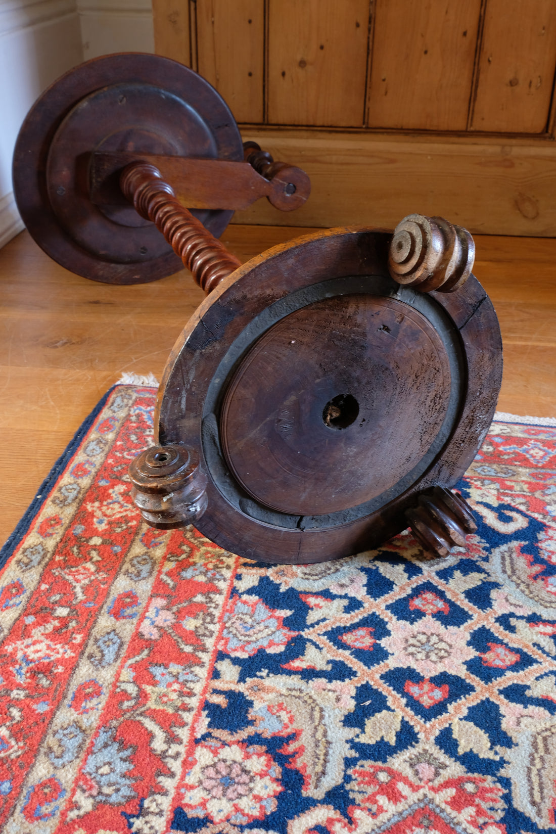 Underside of mid-Victorian burr walnut candle stand showing the segmented lead-weighted ring within the circular platform base
