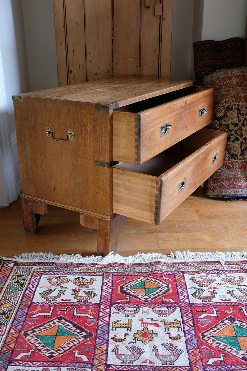 Side view of mahogany campaign chest showing carrying handle and shaped bracket feet