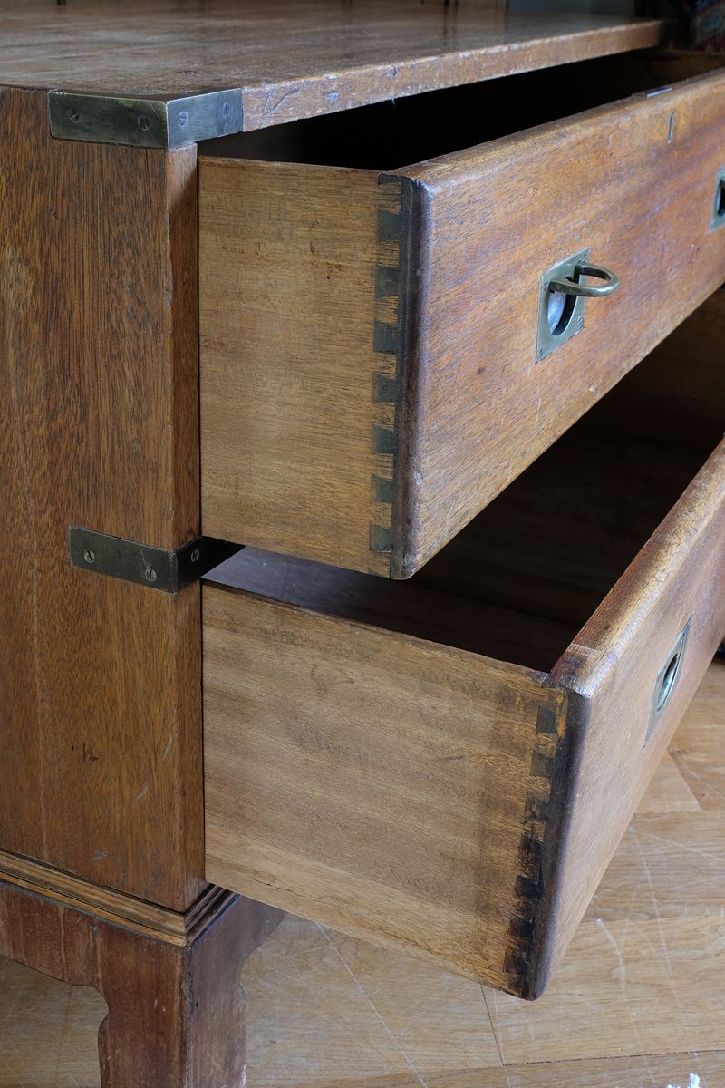 Close view of rounded drawer front and recessed brass campaign pull