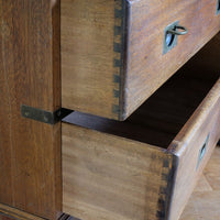 Close view of rounded drawer front and recessed brass campaign pull